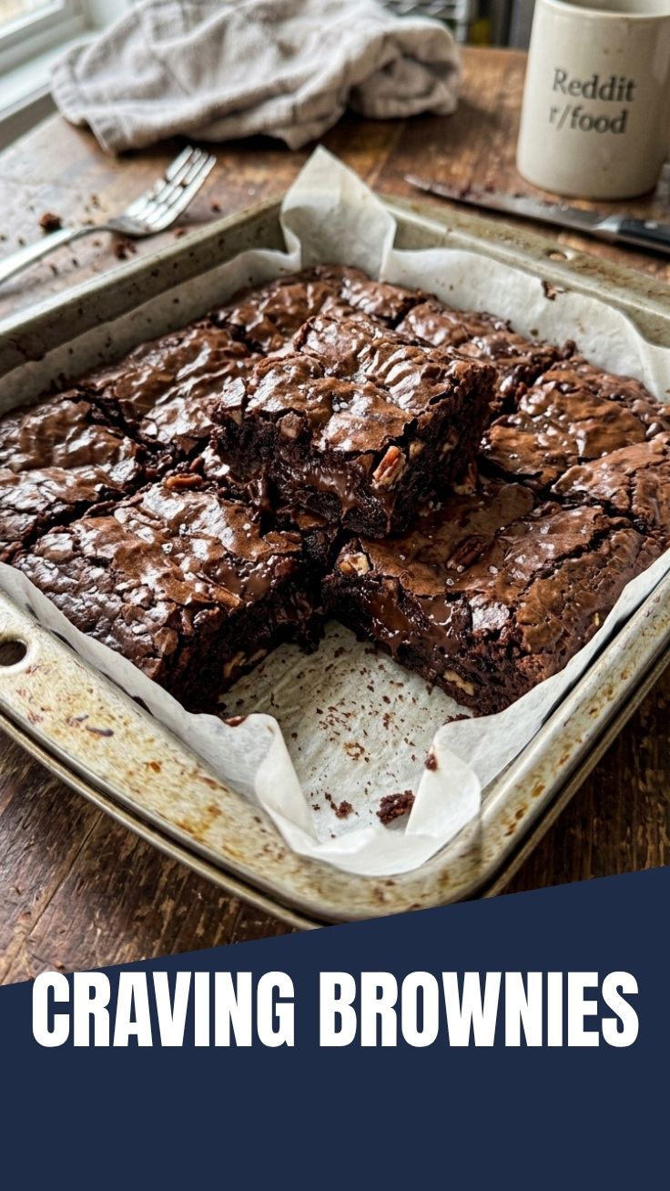 A close-up shot of rich, dark chocolate brownies with a slightly cracked top.